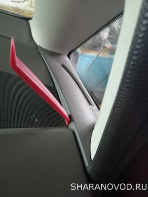 Отжимаем бортик накладки по направлению к треугольному окошку